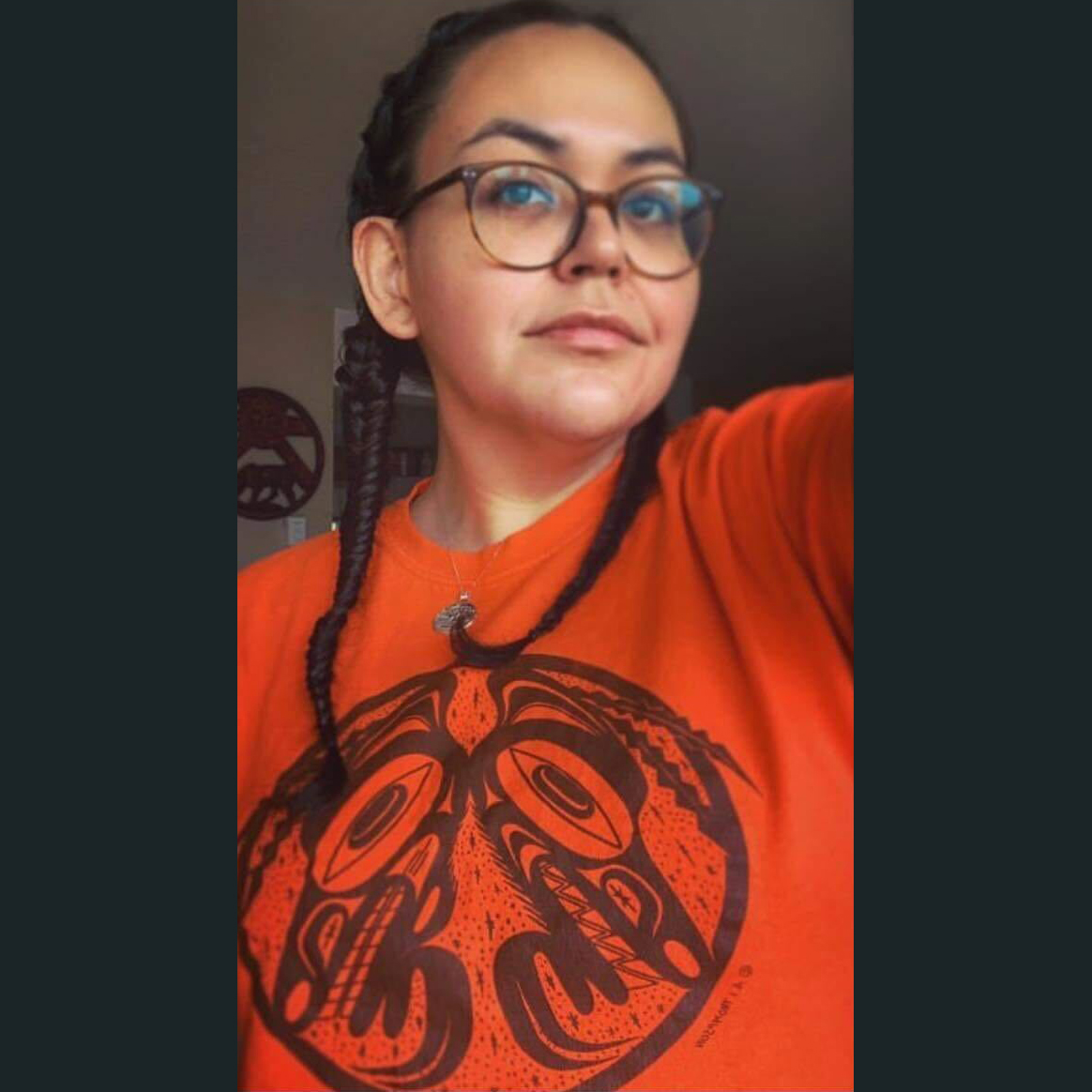 Indigenous woman wearing an orange shirt.